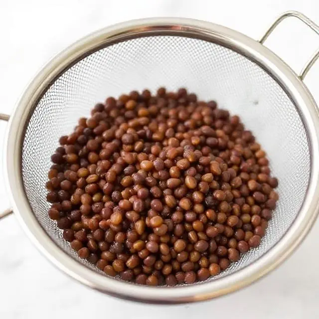 Rinsing lentils in a strainer to remove debris